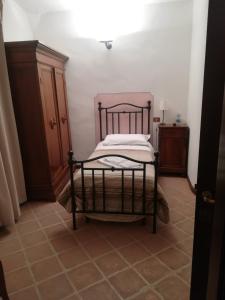 - une chambre avec un lit dans un dortoir doté de carrelage dans l'établissement Foresteria Poggio Bonelli, à Castelnuovo Berardenga