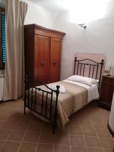 - une chambre avec un lit et une armoire en bois dans l'établissement Foresteria Poggio Bonelli, à Castelnuovo Berardenga