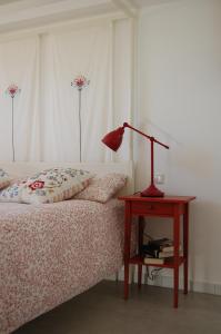 a bedroom with a bed and a table with a lamp at Bed & Breakfast La Volpe e L'Uva in Santa Marinella