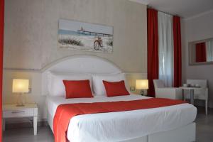 ヴァラッツェにあるHotel Lidoのベッドルーム1室(大型ベッド1台、赤い枕付)