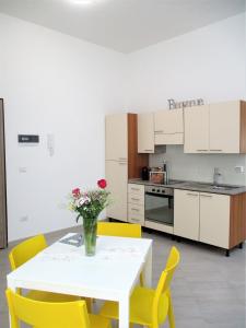 une cuisine avec une table blanche et des chaises jaunes dans l'établissement B&B Bellini Appartamento, à Acquaviva delle Fonti