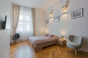 1 dormitorio con 1 cama, 1 silla y 1 ventana en Krakow For You Budget Apartments, en Cracovia
