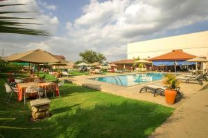 una piscina del resort con tavoli, sedie e ombrelloni di The Smith Hotel a Kisserian