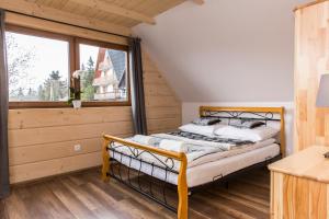 a bedroom with a bed and a large window at udanypobyt Domek Góralski Zakątek in Kościelisko