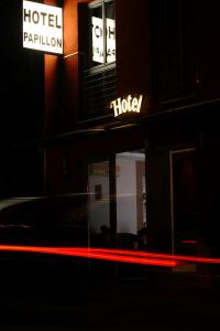 a neon sign on a street corner at night at Hotel Papillon in Budapest