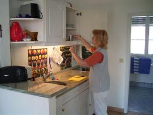 a woman standing in a kitchen preparing food at Villa Linke am Bodensee in Nonnenhorn