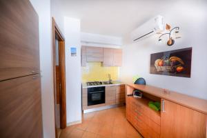 a kitchen with white walls and wooden cabinets at Casa Marta in Cefalù