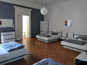 three beds in a room with a wooden floor at Apartments Týnská 7 in Prague