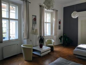 un soggiorno con tavolo, sedie e finestre di Apartments Týnská 7 a Praga