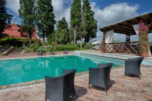 een zwembad met stoelen en een prieel bij Tenuta Cambiano by PosarelliVillas in Castelfiorentino