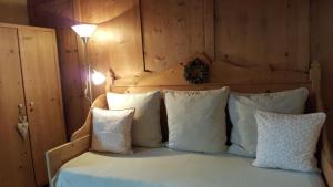 1 dormitorio con 1 cama con almohadas blancas en Landhaus Strickenmacher en Sillian
