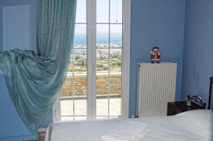 a bedroom with a bed and a large window at The Blue Horizon Villa in Livadi