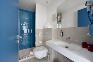 a bathroom with a toilet and a sink at Hôtel Les Voiles in Toulon +27 photos