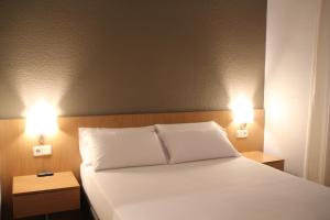 
a hotel room with a bed and a lamp at Hostal Abodi in Pamplona
