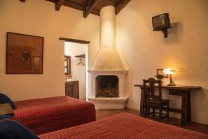 a room with two beds and a fireplace at Posada El Antaño in Antigua Guatemala