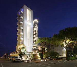 a large building with a building with a tower at Hotel Delle Nazioni in Lido di Jesolo