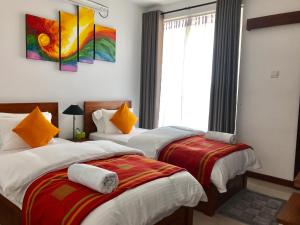 een slaapkamer met 2 bedden en een raam bij Araliya OceanFront Condos Nilaveli, Trincomalee in Nilaveli