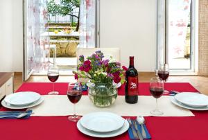 une table avec deux verres de vin et un vase de fleurs dans l'établissement Apartmani AMI, à Podstrana
