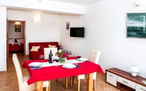 une salle à manger avec une table et des chaises rouges dans l'établissement Apartmani AMI, à Podstrana