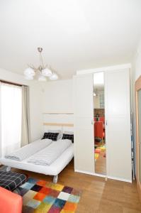 een witte slaapkamer met een bed en een spiegel bij Apartman Mozartova in Praag