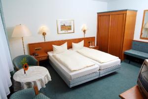 a hotel room with a bed and two chairs at Gasthof-Hotel Maintal in Bad Staffelstein