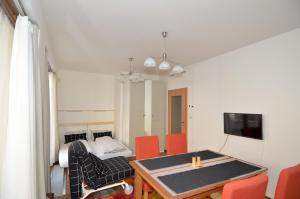 een kamer met een tafel en stoelen en een bed bij Apartman Mozartova in Praag