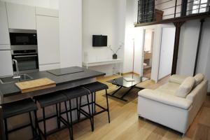 a kitchen and living room with a table and a couch at Atout Carmes in Toulouse