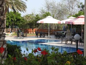 a pool with tables and chairs and umbrellas at Anna Hotel Apartments in Paphos
