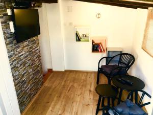 a room with two chairs and a television on a wall at Komiza Provita Guesthouse in Komiža
