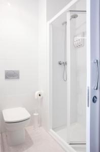 y baño blanco con aseo y ducha. en Live & Dream, en Barcelona