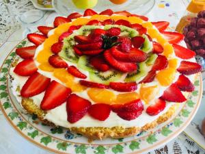 a cake with strawberries and oranges on a plate at Hotel Scilla in Scilla