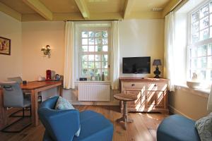 a living room with a desk and a tv at B&B Lhee-Gaarde in Dwingeloo