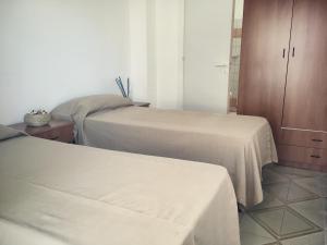 リド・マリーニにあるSoleMareSalento Ptのベッドルーム1室(ベッド2台、キャビネット付)