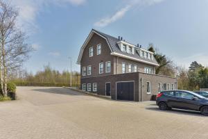 a large house with a car parked in front of it at Luxury Family Residence Schinkeldijkje in Aalsmeer