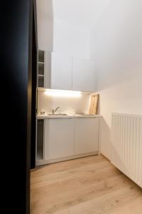 a kitchen with white cabinets and a sink at Schloss Pesenbach Chalet im Freizeitland Feldkirchen an der Donau in Feldkirchen an der Donau