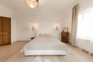 a white bedroom with a white bed and a window at Schloss Pesenbach Chalet im Freizeitland Feldkirchen an der Donau in Feldkirchen an der Donau