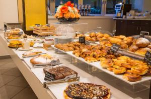 a counter filled with lots of different types of pastries at Best Western City Hotel in Bologna