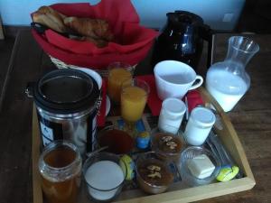 una bandeja de comida con tazas y bebidas en una mesa en Cellier de l'abbaye - L'Ermitage, en Vézelay