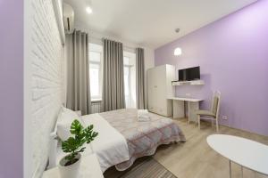 1 dormitorio con cama, mesa y escritorio en Bessarabka Apartments, en Kiev