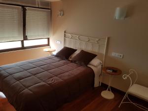 a bedroom with a large bed and a window at Pensión Arenal in San Vicente de la Barquera