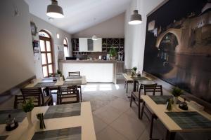 a restaurant with tables and chairs and a kitchen at Villa Divani in Mostar