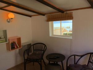 a room with two chairs and a table and a window at Komiza Provita Guesthouse in Komiža