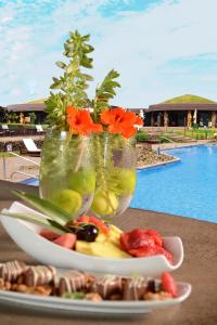 a table with a plate of food and two vases with flowers at Nayara Hangaroa in Hanga Roa