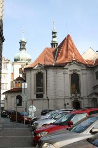 a large building with cars parked in a parking lot at Epstein Apartments in Prague