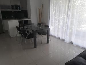 una mesa negra y sillas en una habitación con ventana en Departamento En Tigre en Tigre