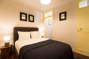 ein Schlafzimmer mit einem Bett, zwei Lampen und einer Tür in der Unterkunft Olá Lisbon - Rato Terrace IV in Lissabon