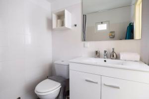 a white bathroom with a toilet and a sink at Olá Lisbon - Rato Terrace IV in Lisbon