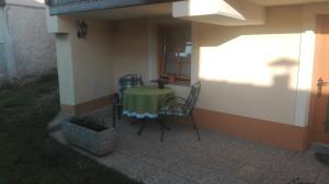 a patio with a table and chairs on the side of a house at Apartma Tim Mušič in Črnomelj