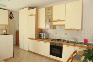 a kitchen with white cabinets and a stove top oven at La casetta della nonna in Sestri Levante +16 photos