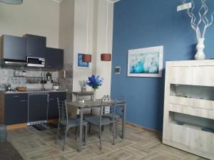 a kitchen with a table and a blue wall at Mishalay Apartment in Syracuse